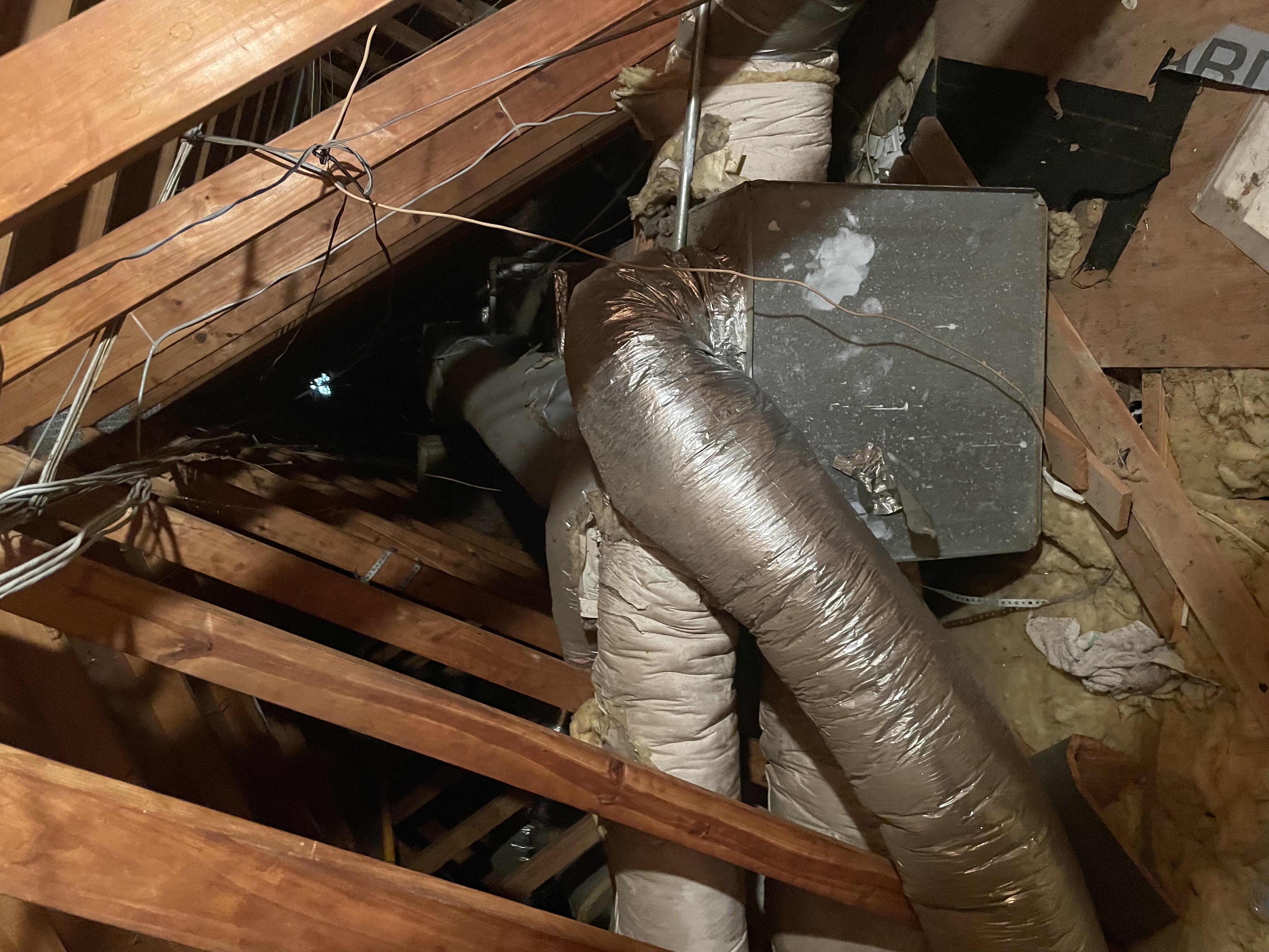 Aging attic flex ductwork connected to a metal plenum box