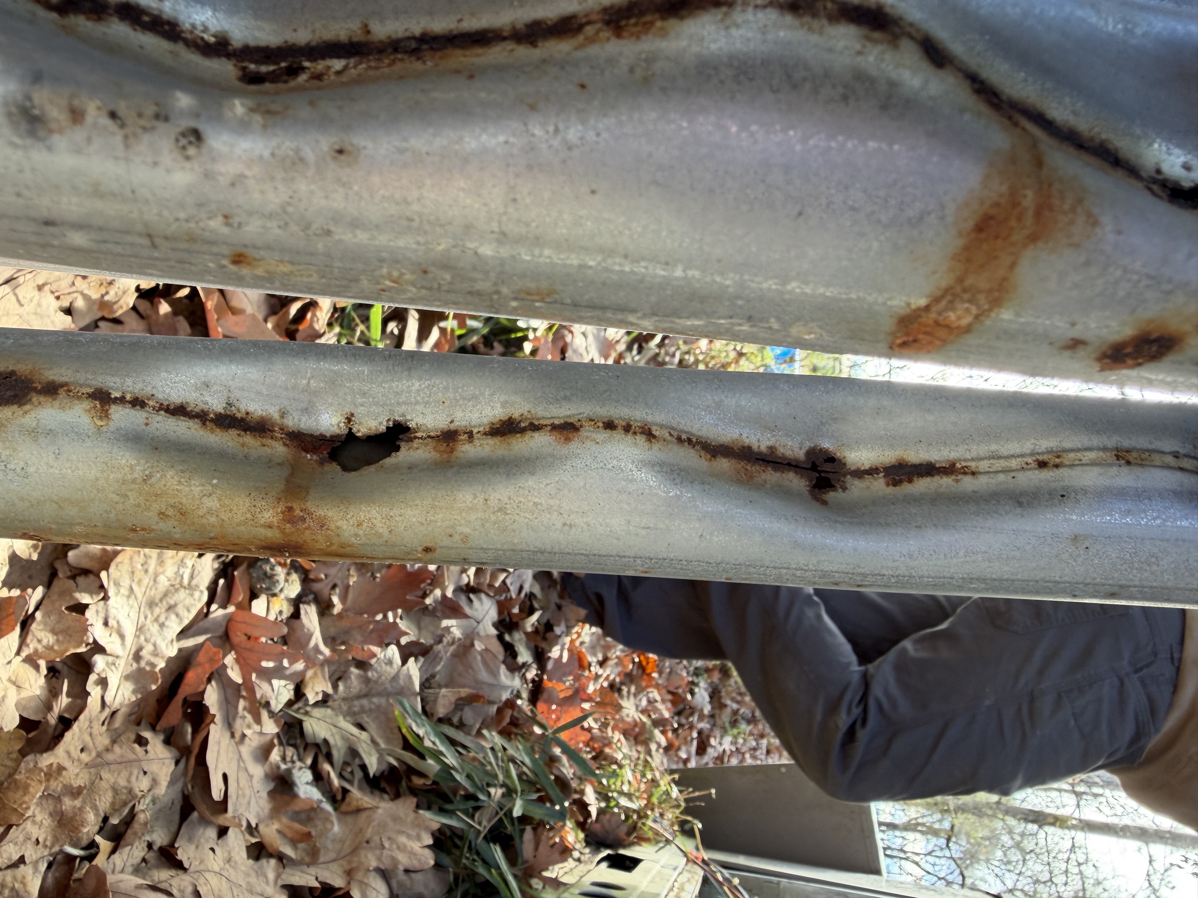 Close-up of a furnace heat exchanger with a hole rusted clean through the metal