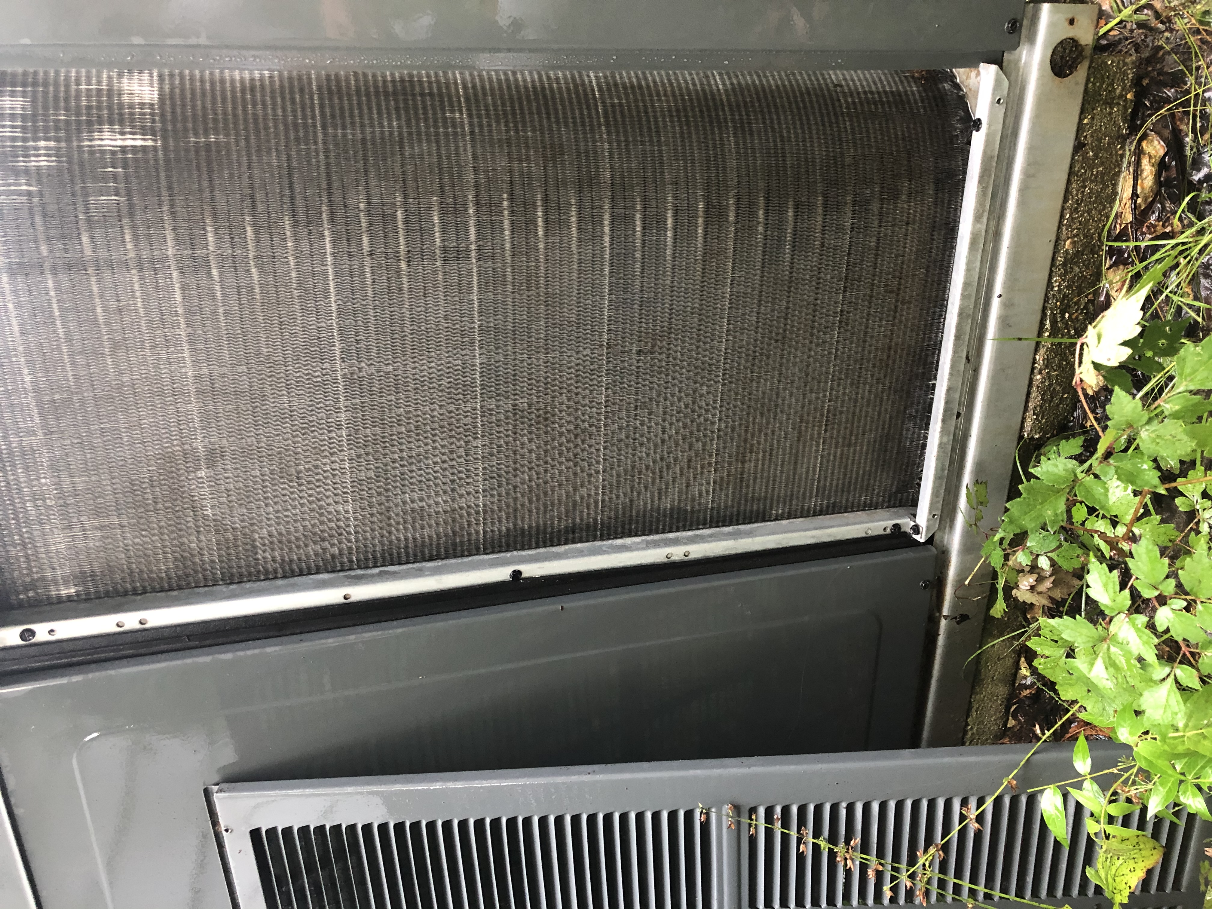 A freshly cleaned HVAC condenser coil with water still beading on the fins