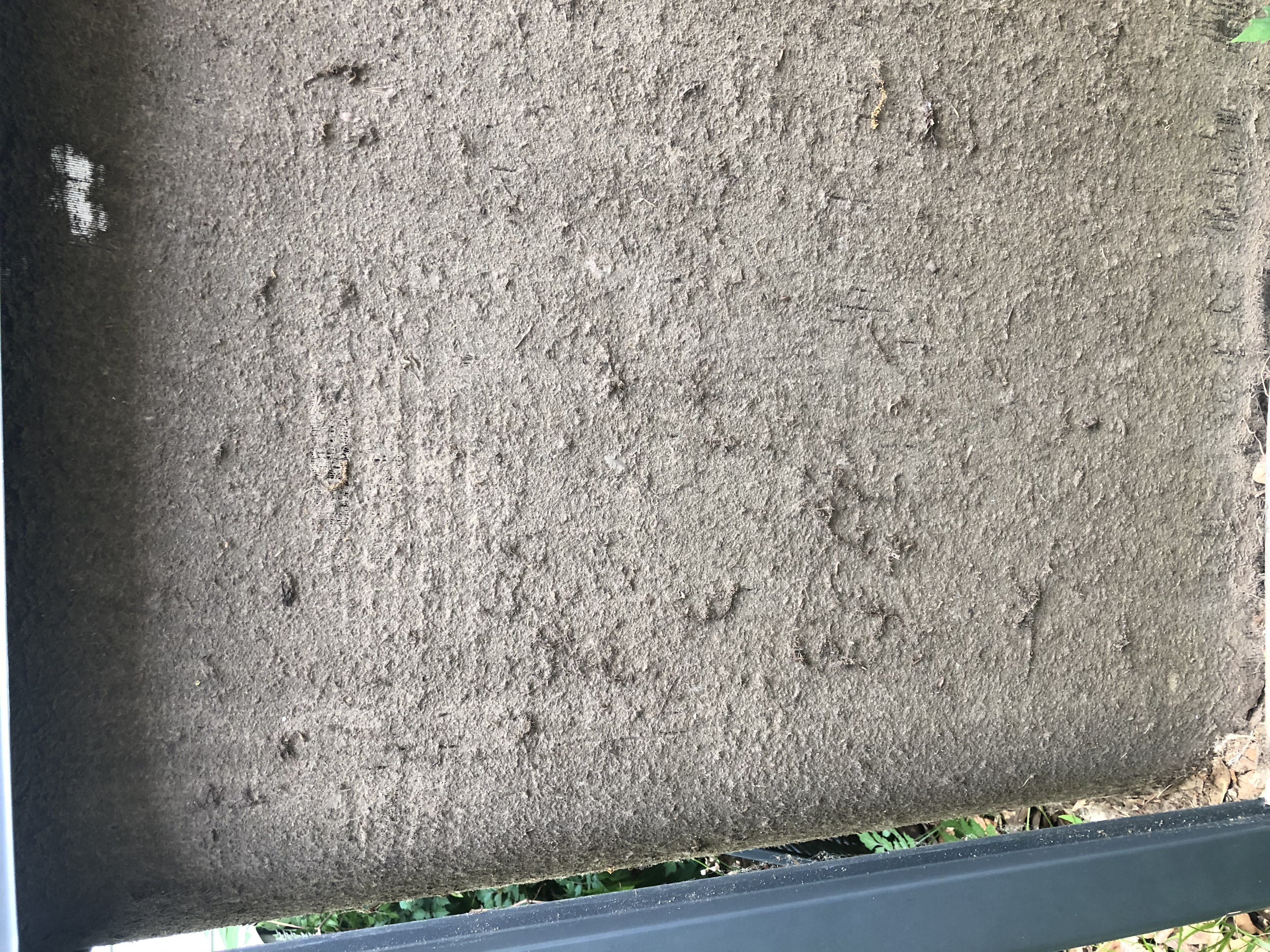 Extreme close-up of an HVAC coil completely matted with caked-on dirt and debris